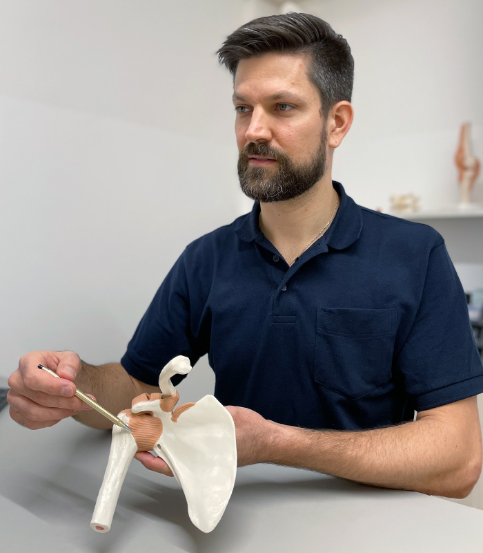 Dr Lukas Greiner mit Modell eines Schultergelenks